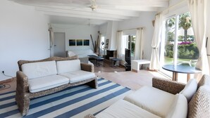 Amplia sala de estar con sofá, mesa de comedor y televisor.