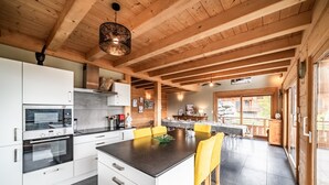 A modern kitchen with white cabinets, a central island, and yellow bar stools. - Chalet 'Célestine 7 Bedrooms - Sauna' with Mountain View, Private Terrace and Wi-Fi (Verchaix)