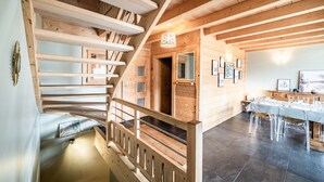 A wooden interior with a staircase, a dining area, and framed pictures on the walls. - Chalet 'Célestine 7 Bedrooms - Sauna' with Mountain View, Private Terrace and Wi-Fi (Verchaix)