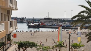 A beach with a boat dock, people, and a Burger King sign.