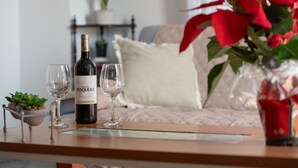A table with a bottle of wine, two glasses, and a small plant.