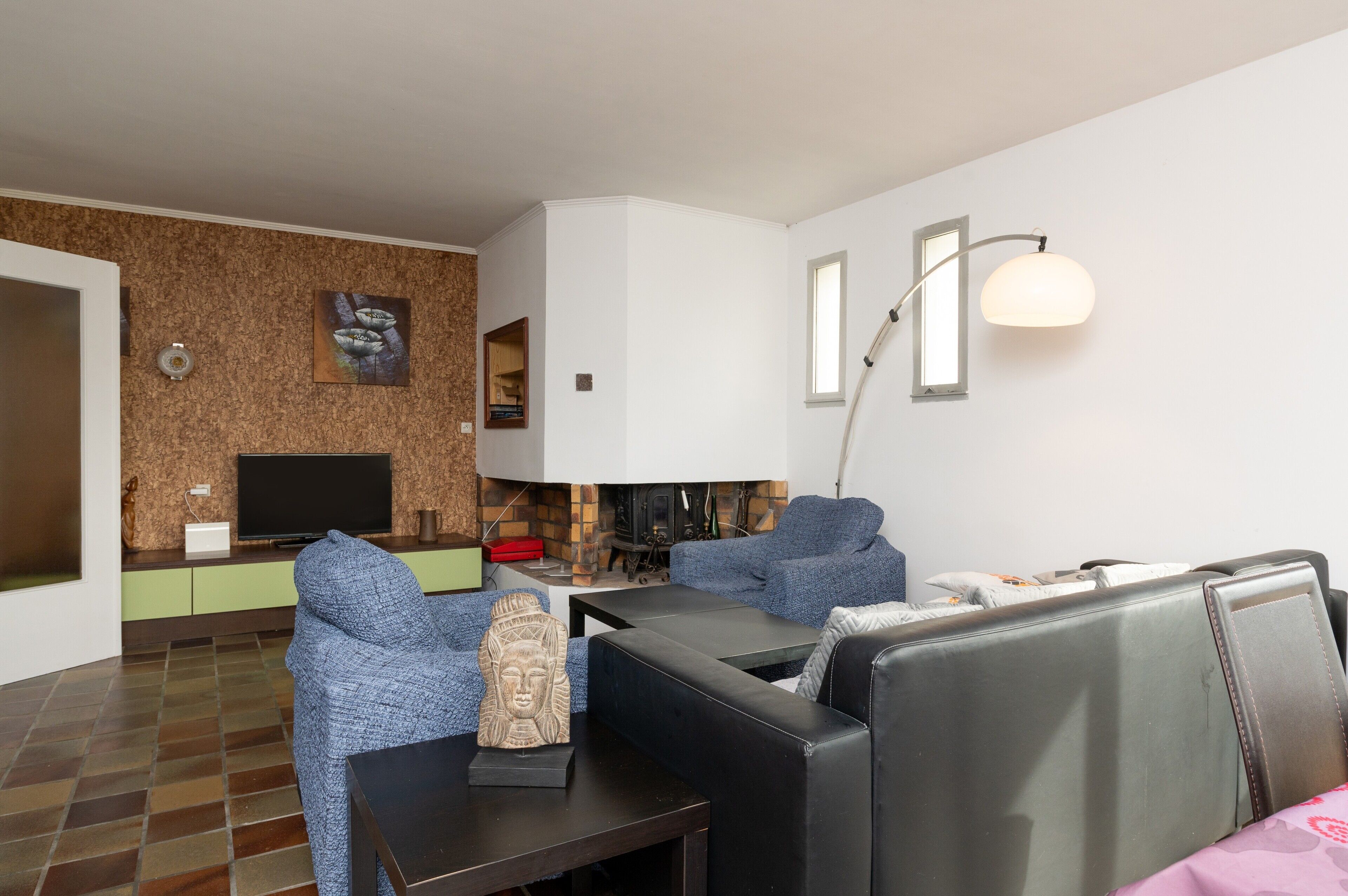 Un soggiorno moderno con una TV a schermo piatto, un caminetto e un divano.