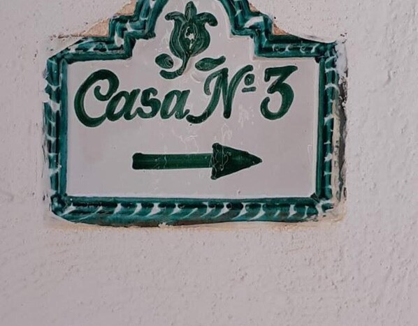 A ceramic sign with 'Casa N°3' and an arrow pointing right, mounted on a wall.