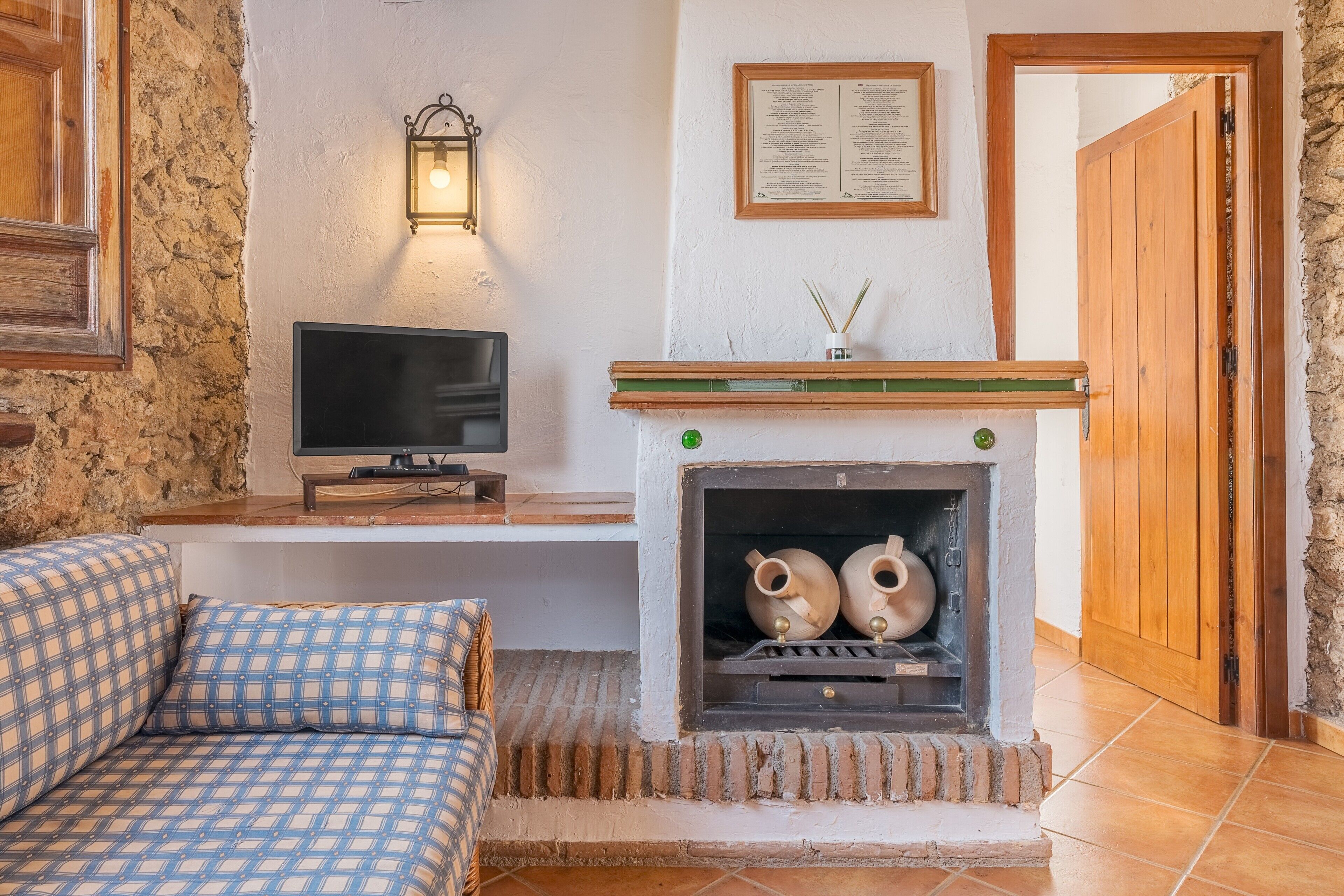 A room with a fireplace, a television, and a sofa.