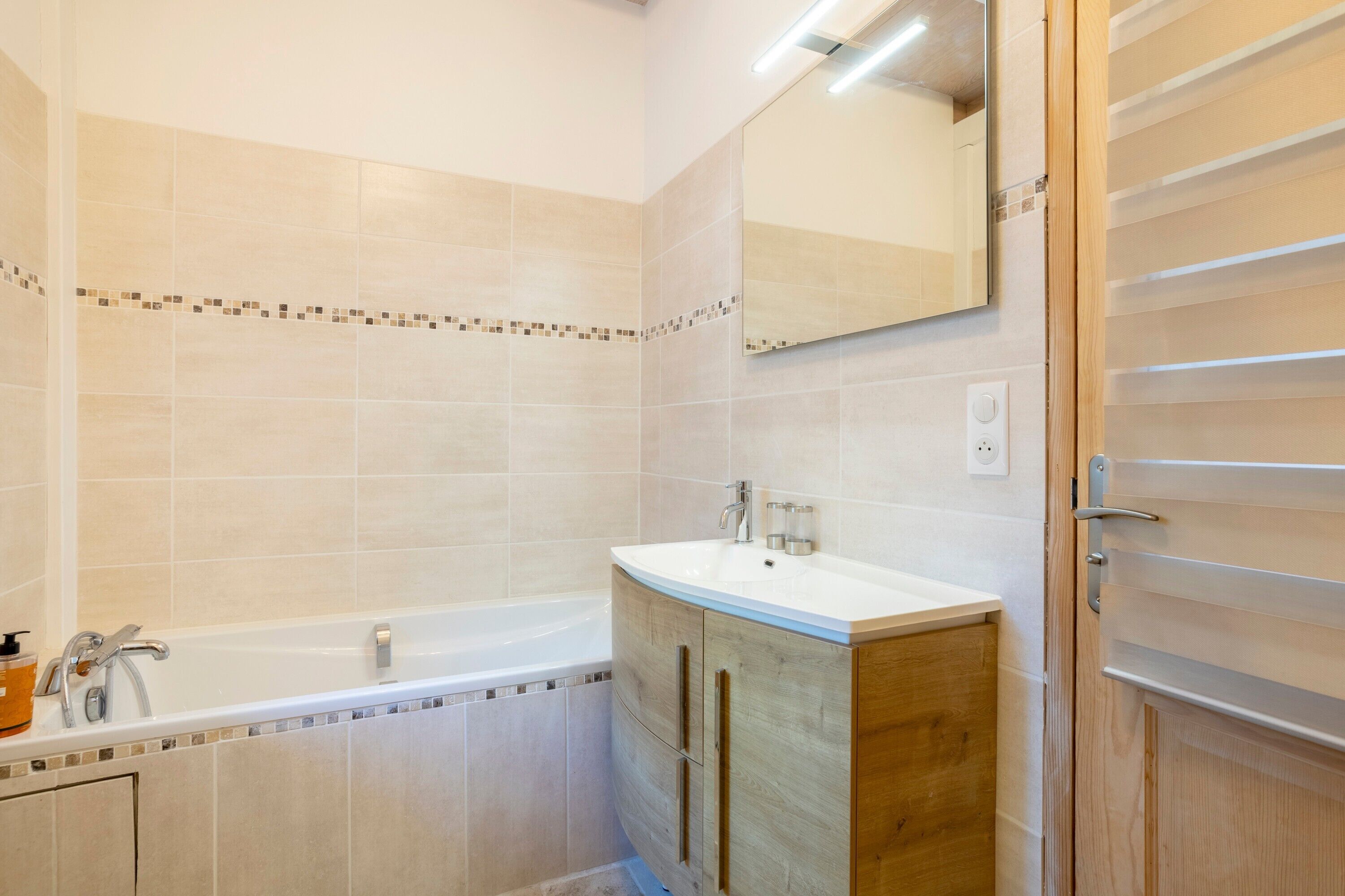 Ein Badezimmer mit einer Badewanne, einem Waschbecken und einem Spiegel.