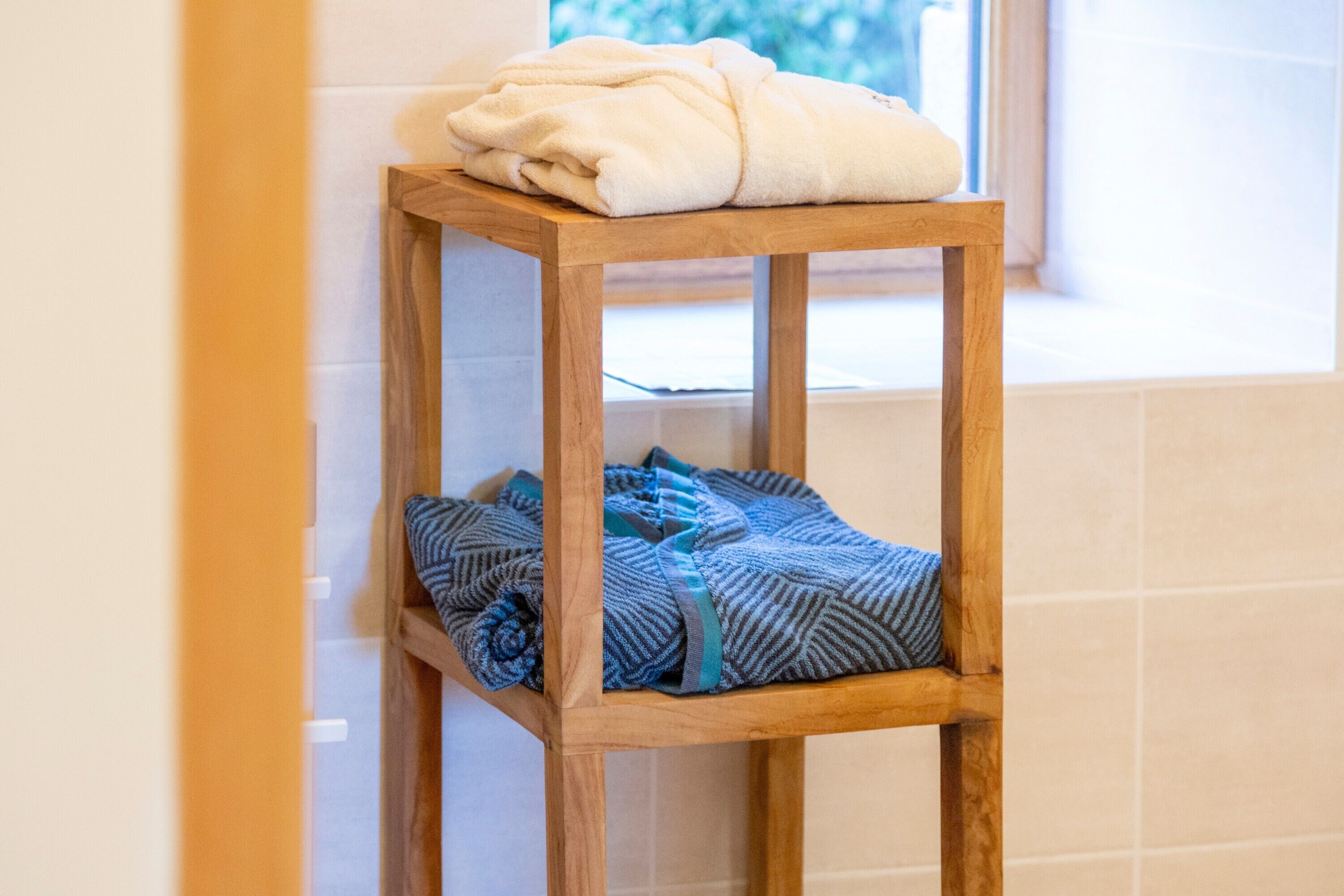 A wooden stool with folded towels.