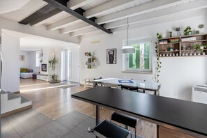 Une cuisine moderne avec un coin repas, des poutres en bois au plafond et une fenêtre offrant une vue agréable.