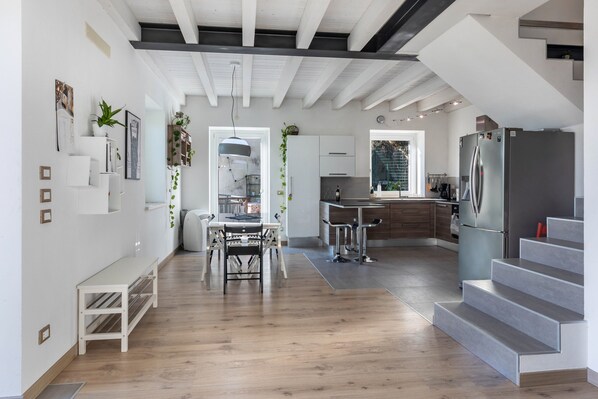 Eine moderne Küche mit integriertem Kühlschrank, Holzboden und einer Treppe zu einer oberen Ebene.