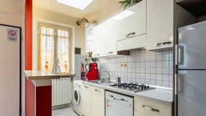 Una cocina moderna con lavadora, lavavajillas y una cafetera roja.