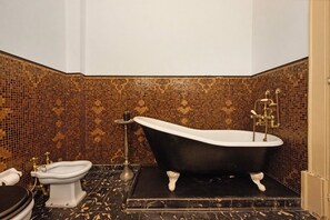 Ein Badezimmer mit freistehender Badewanne, Waschtisch und Toilette.
