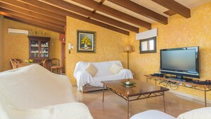 A living room with a sofa, a coffee table, a TV, and a wooden ceiling. - Holiday Home 'Can Nadal - Adults Only' with Mountain View, Wi-Fi and Air Conditioning (Sineu)
