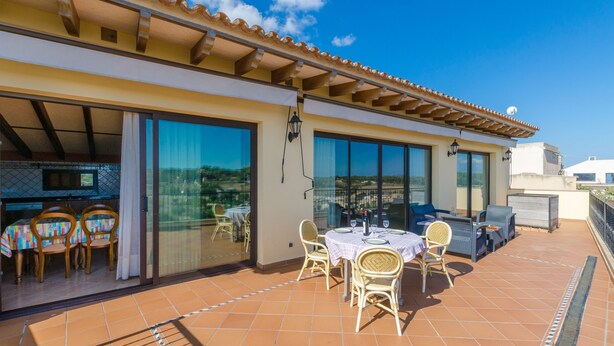 A terrace with a table and chairs, a TV, and a view of the landscape. - Holiday Home 'Can Nadal - Adults Only' with Mountain View, Wi-Fi and Air Conditioning (Sineu)