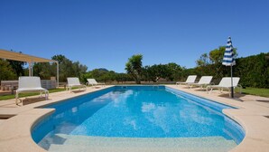 A rectangular swimming pool with a tiled edge, surrounded by white lounge chairs and a single umbrella. - Country House 'Cati Ref 57' with Private Pool, Wi-Fi and Air Conditioning (Son Servera)