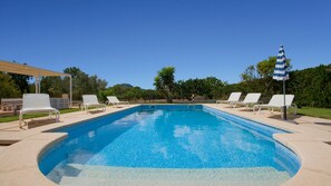 A rectangular swimming pool with a tiled edge, surrounded by white lounge chairs and a single umbrella. - Country House 'Cati Ref 57' with Private Pool, Wi-Fi and Air Conditioning (Son Servera)