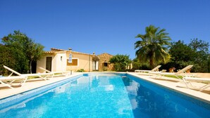 A swimming pool with lounge chairs, a building with a tiled roof, and palm trees. - Country House 'Cati Ref 57' with Private Pool, Wi-Fi and Air Conditioning (Son Servera)