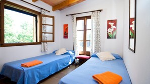 A room with two beds, a window, and a door.