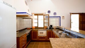 Una cocina con horno empotrado, microondas y pileta doble.