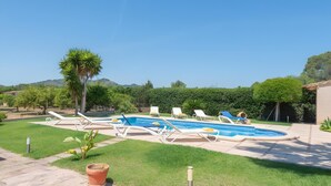 A backyard with a swimming pool, lounge chairs, a palm tree, and a well-maintained lawn. - Country House 'Cati Ref 57' with Private Pool, Wi-Fi and Air Conditioning (Son Servera)