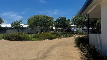 A gravel driveway leading to a building with a covered porch.