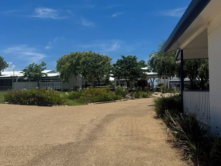 A gravel driveway leading to a building with a covered porch.