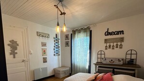 Ein Schlafzimmer mit zwei Betten, einem Deckenventilator, Wanddekorationen und einer Kommode.