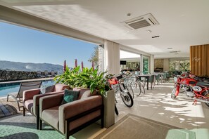 Un interior moderno con piscina, zona de estar y una motocicleta.