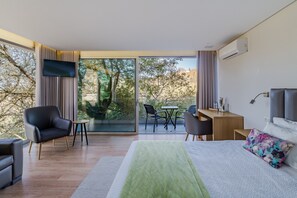 Una habitación de hotel moderna con una cama, un escritorio, una silla y un televisor.
