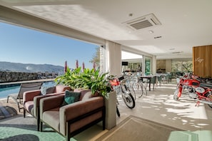 Un intérieur moderne avec une piscine, un coin salon et une moto.