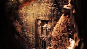 A narrow passageway with ancient rock-cut architecture, including columns and a carved doorway. - Petra Agora Hotel (Wadi Musa)