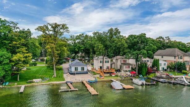 Un quartier résidentiel au bord du lac, avec des maisons, des quais et des bateaux.