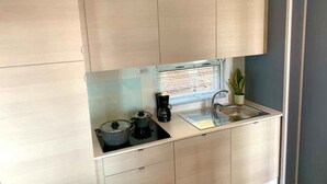 A compact kitchen with a sink, stove, and cabinets. - Mobile home with terrace with lake view, pool and air conditioning (Padenghe sul Garda)