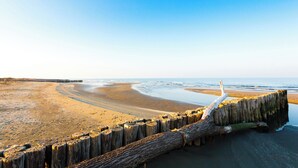 Une plage dotée d’une digue en bois et d’une jetée qui s’avance dans l’eau.