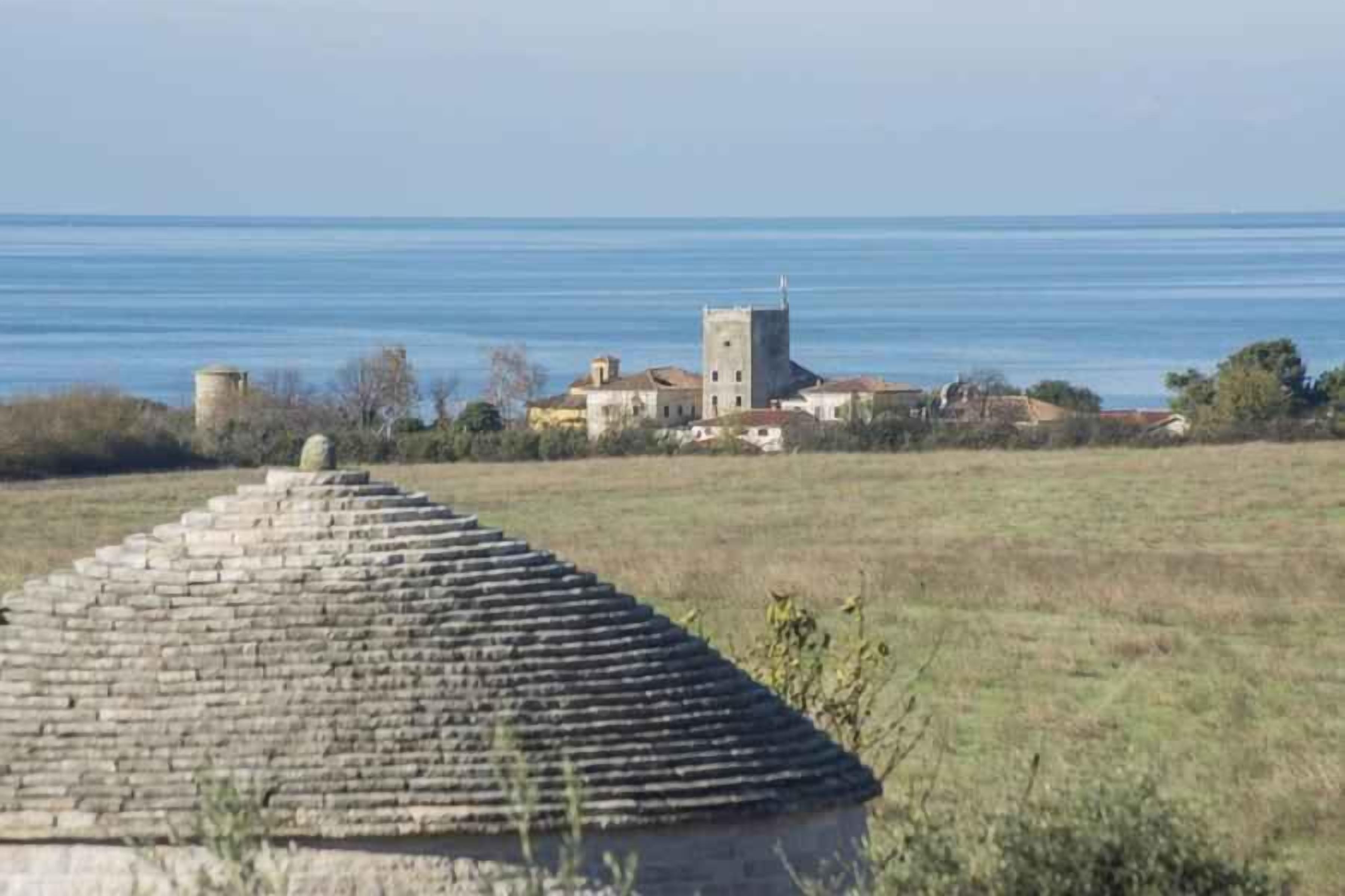A coastal village with a prominent tower and traditional buildings.