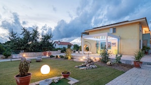 A modern house with a well-maintained garden, outdoor seating area, and a patio. - Ammentos by Interhome (Marina di Sorso)