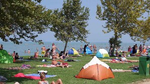 A beach scene with tents, people sunbathing, and a clear sky. - Holiday apartment near the water with WLAN and air conditioning (Zamárdi)