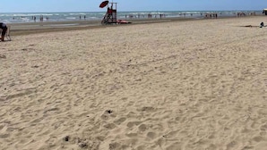 A beach with a lifeguard tower and a clear blue sky. - Mobile home with air conditioning, terrace and pool (Caorle)