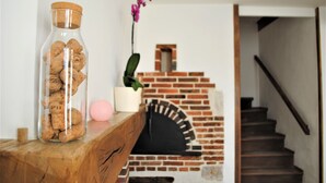 Een glazen pot gevuld met kurken, een roze bal en een plant in een potje op een houten ondergrond.