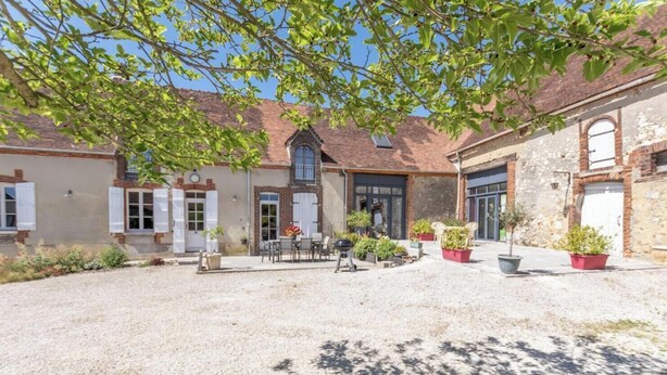 A property with a gravel courtyard, outdoor seating, and a brick building with multiple windows and doors. - Gite Du Grand Val 2 - ALLEMANT (ALLEMANT)