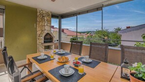 Un comedor con chimenea de piedra, mobiliario exterior y vistas del paisaje circundante.