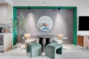 A modern kitchen with a round dining table, two chairs, and a potted plant. - Ava's Suite 37th FLR PALMS PLACE (Las Vegas)