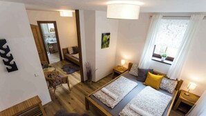 Ett modernt hotellrum med en stor säng, ett litet skrivbord, en stol och ett badrum som syns genom en öppen dörr.