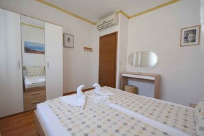 Una habitación de hotel con una cama, un armario, un espejo y una puerta.