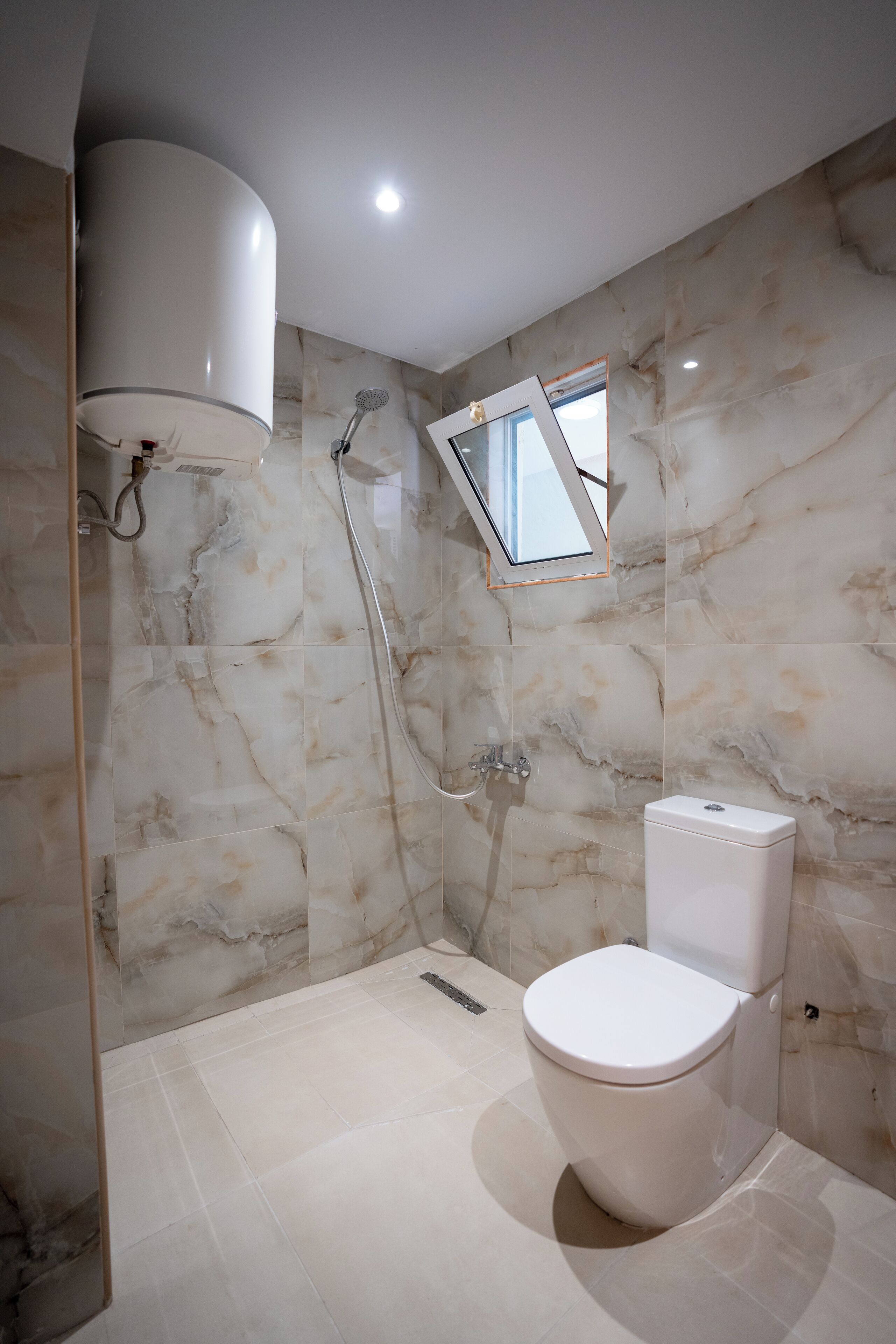 Ein modernes Badezimmer mit Toilette, Dusche und Dachfenster.