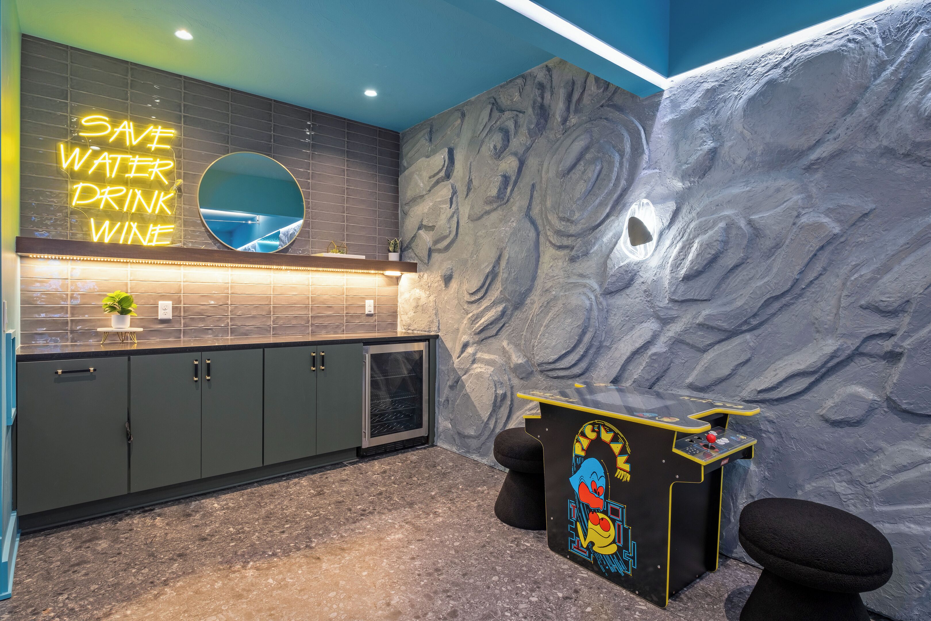 A modern kitchen with a neon sign, a marble backsplash, and a unique wall design.