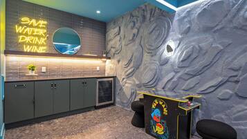 A modern kitchen with a neon sign, a marble backsplash, and a unique wall design.