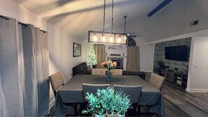 A dining area with a long table, chairs, a chandelier, a Christmas tree, and a fireplace. - Near universal studios Charming 4bed house with WiFi, AC in enjoyable Orlando (Orlando)