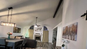 A modern living room with a dining area, a fireplace, and a staircase leading to another level. - Near universal studios Charming 4bed house with WiFi, AC in enjoyable Orlando (Orlando)