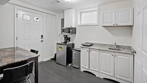 A compact kitchen with white cabinets, a microwave, a coffee maker, and a small refrigerator. - Private Capitol Heights Guest Suite near Metro with Laundry (Capitol Heights)