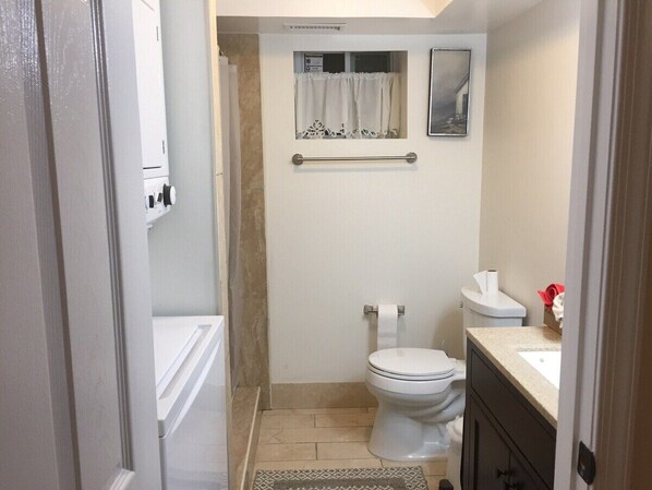 Une petite salle de bain comprenant des toilettes, un petit lavabo et un porte-serviettes.