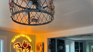 Una cocina acogedora con un letrero de neón, una mesa de comedor de madera y armarios.